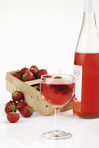 篮子里有新鲜草莓，玻璃杯里有草莓酒