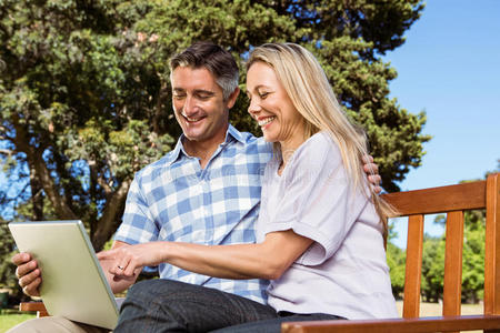 一对夫妇在公园里用笔记本电脑放松