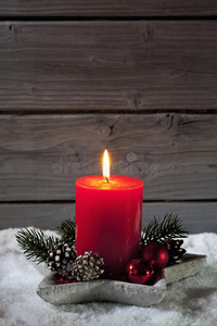圣诞蜡烛在烛台上的雪堆木制背景下