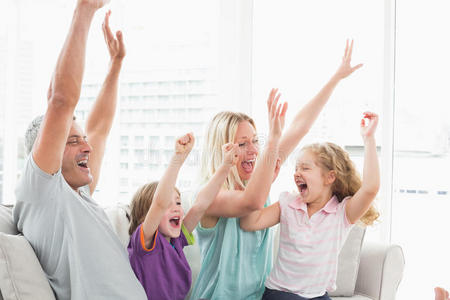 一家人一边看电视一边庆祝成功