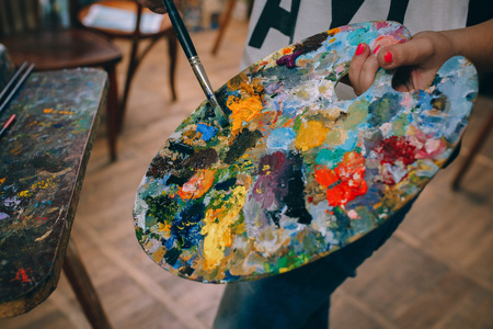 用油漆刷手手拿着用油画颜料调色板照片