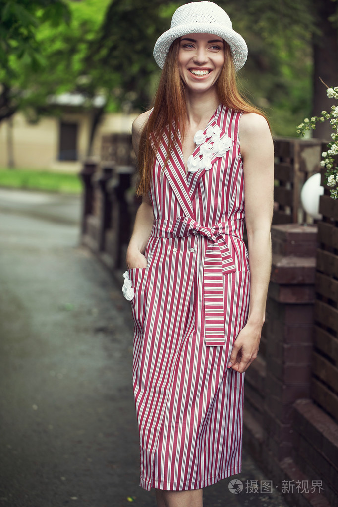 照片 时尚年轻漂亮的女孩穿着休闲服装 (衣服和运动鞋) 雨后走过城市