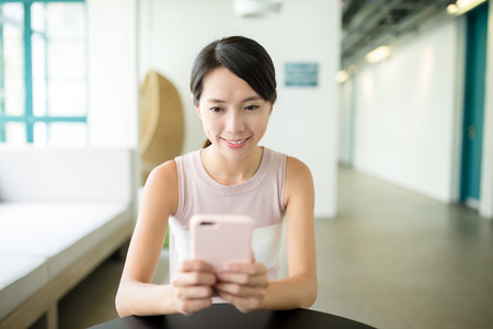 在咖啡馆中使用移动电话的女人图片