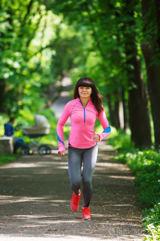 年轻的健身女人在森林步道运行
