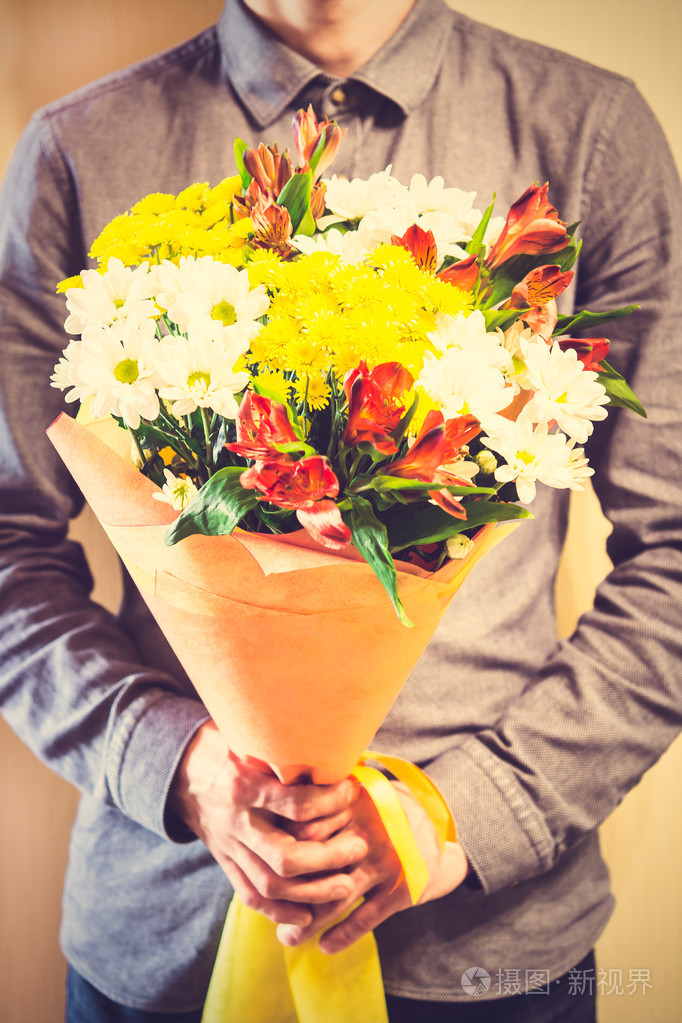 男子手持的黄色和橙色玫瑰花束妇女s天va