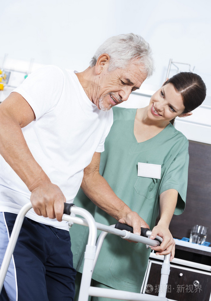 年轻的护士帮助病人在康复中心使用沃克