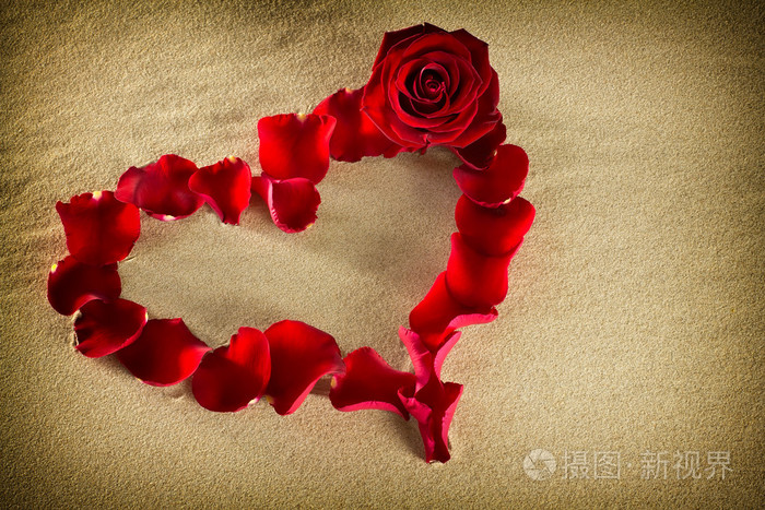 浪漫.在沙滩上的玫瑰花瓣使一颗心