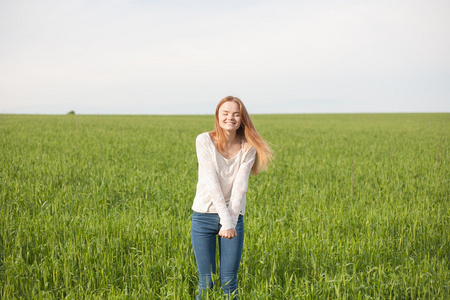 在上午的绿色麦田张开双臂的女人摄影图
