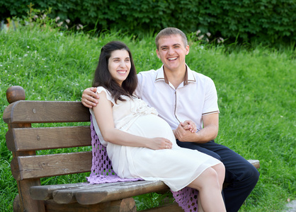 孕妇和丈夫在室外, 幸福的家庭,夫妇在城市公园,夏天的季节,绿草和