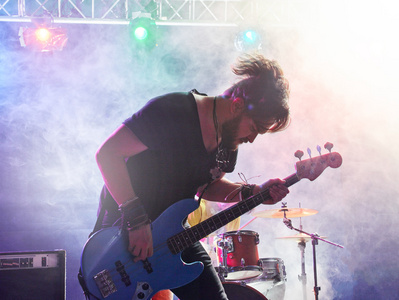 摇滚乐队舞台上进行表演.在前台的贝斯手照片