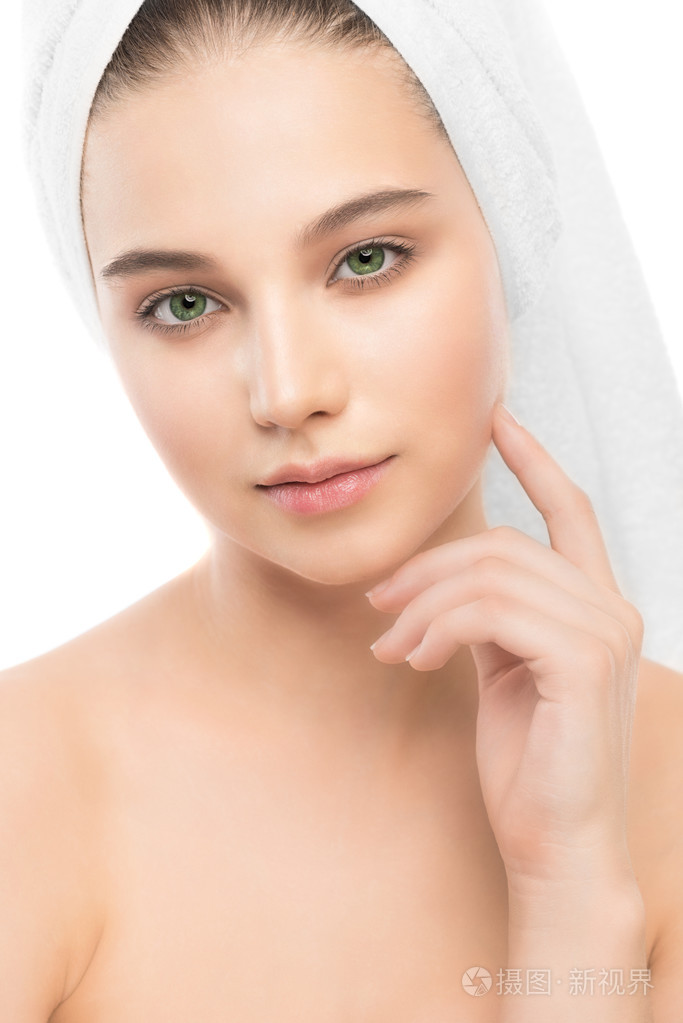 美丽年轻的黑发女人与清洁面部和她头上的毛巾.分离