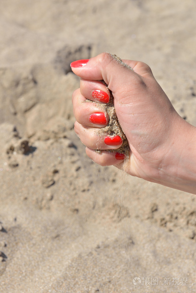 关闭的女性手释放沙子沙子流经