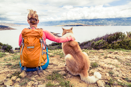 女人与狗看海上的徒步旅行者图片