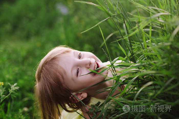 一个可爱的小女孩,在草地上玩耍的室外肖像