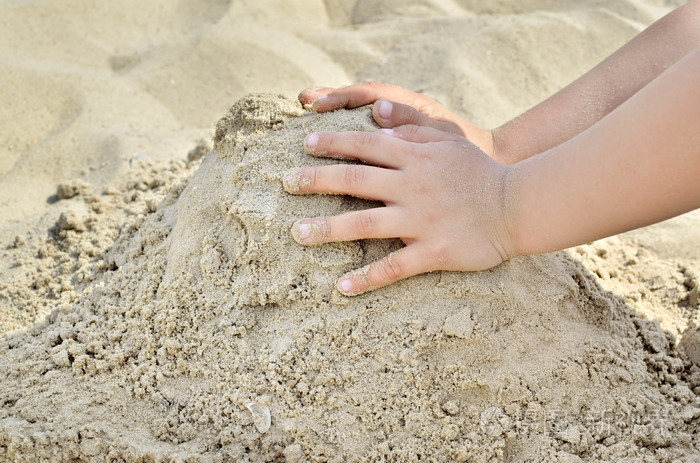 沙子在沙滩上玩耍的小男孩