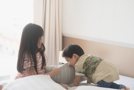 亚洲儿童在宾馆房间的枕头大战图片