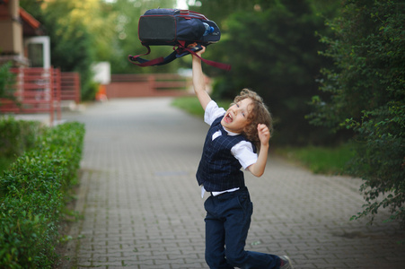 站在学校的院子里的小男生小男孩站在学校院子里,用愤怒的快车校园里