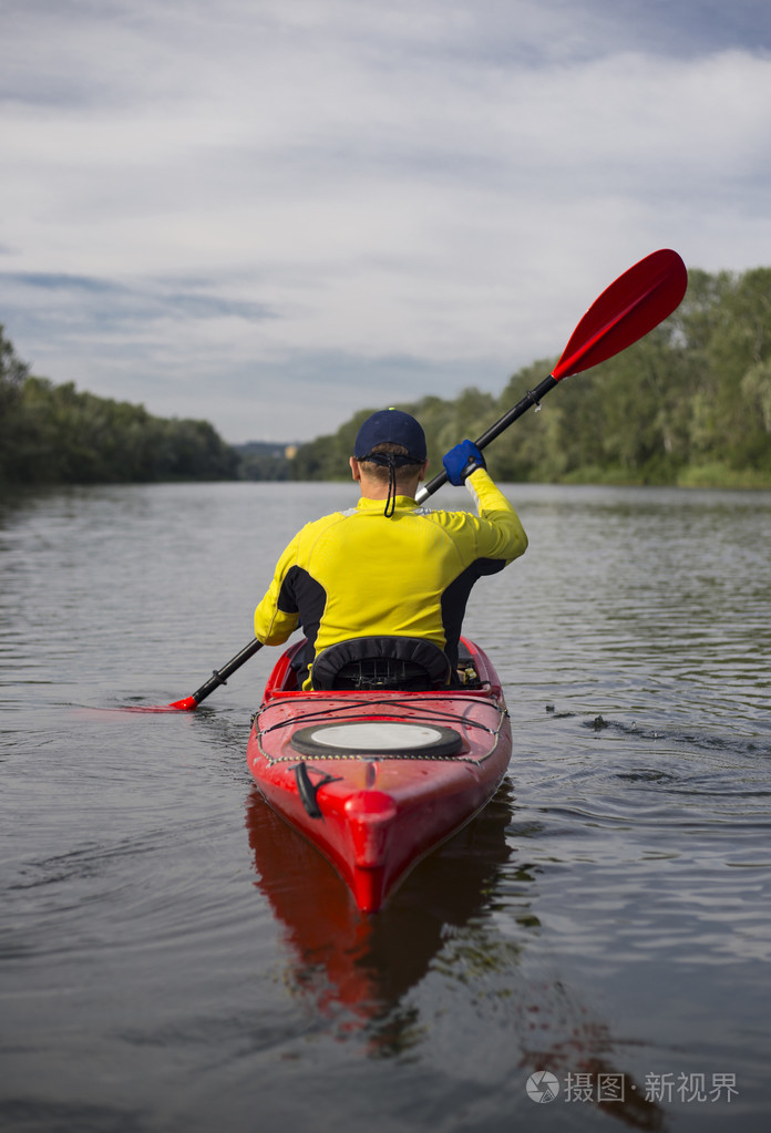 一名男子桨红皮划艇