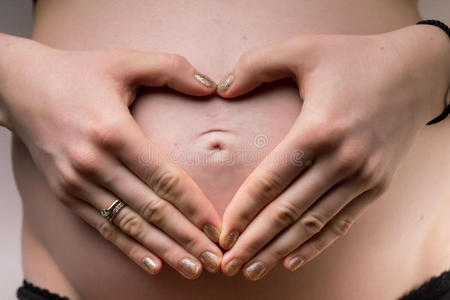 孕妇双手抱着心形的婴儿布
