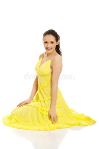 坐在黄色连衣裙上的漂亮女人。