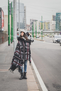 美丽的年轻黑发女郎在城市街道上摆姿势