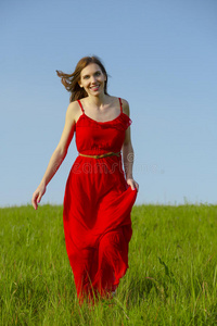 穿着红色连衣裙走路的漂亮女孩