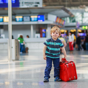 小男孩带着手提箱去机场度假旅行