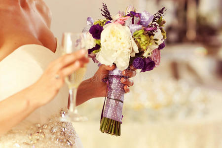 新娘拿着香槟杯和婚礼花束