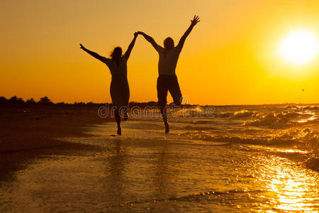 快乐的情侣在沙滩上奔跑