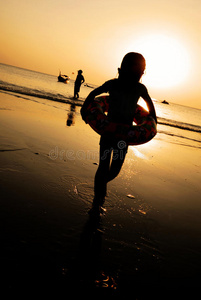 儿童海滩日落假日女孩玩的概念