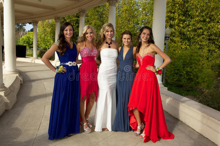 一群十几岁的女孩穿着舞会礼服摆姿势照片