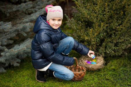 女孩在后院的草坪上找到复活节彩蛋