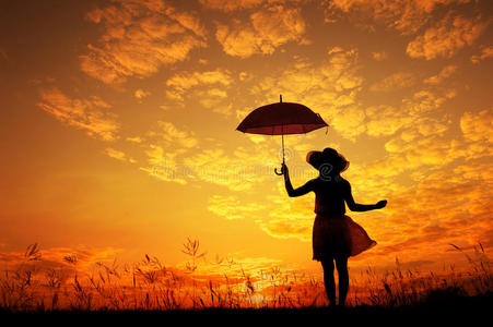 雨伞女子跳跃日落剪影