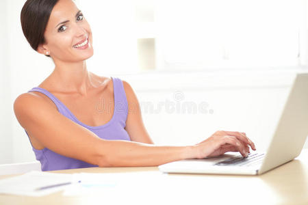 优雅快乐的女性在她的电脑上工作