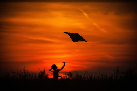女孩和日落时分放风筝图片
