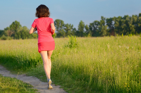 在户外,小路上慢跑的女跑步运动员春天跑步和锻炼照片