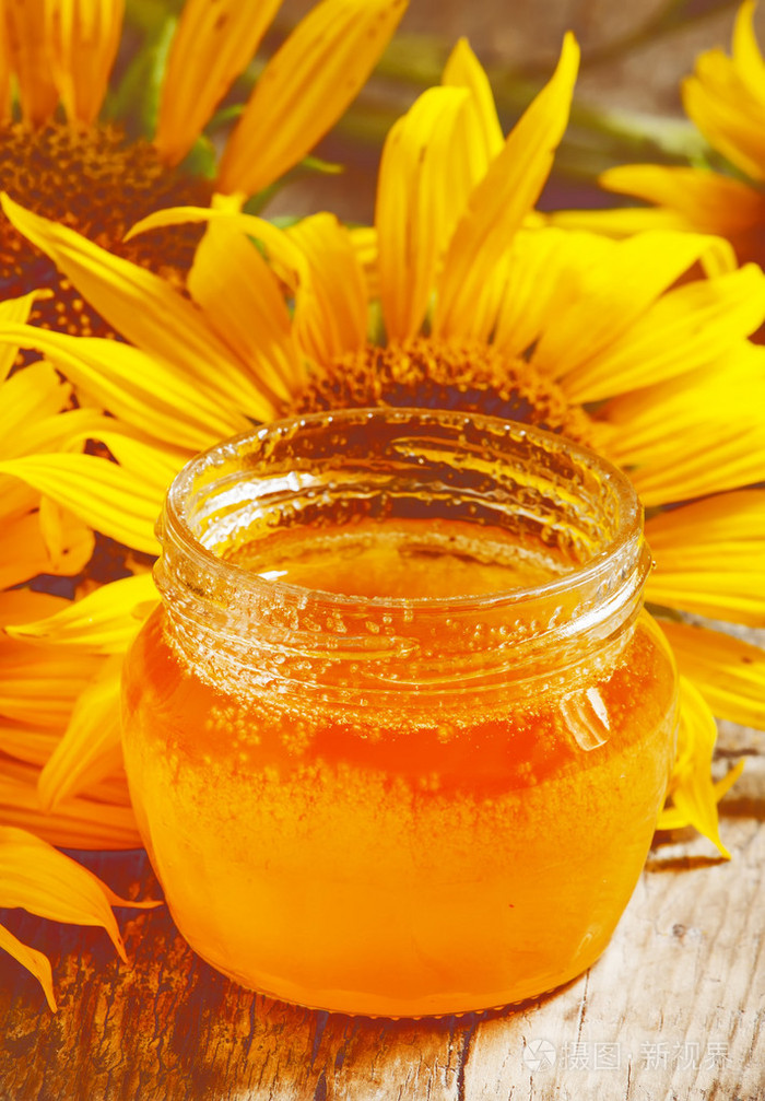 蜂蜜和木制的桌子上的向日葵