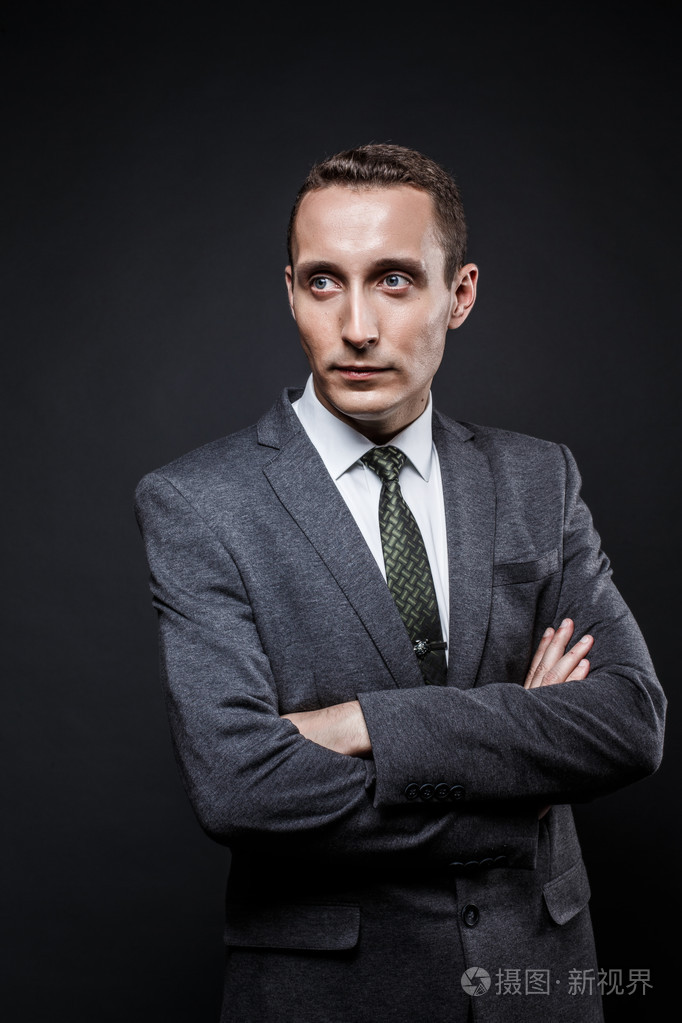 严肃的事情男人棕色头发与富有表现力的脸,穿着灰色西装和领带.