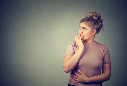 紧张压力有关的少妇咬指甲焦急地寻找照片