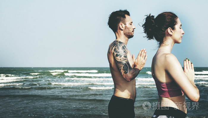 冥想在海滩上的情侣