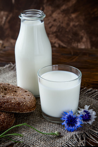 奶与玻璃在木桌上的牛奶瓶图片