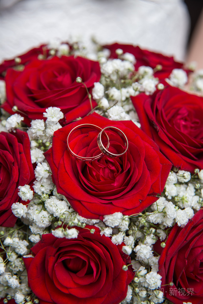订婚戒指和红玫瑰新娘花束