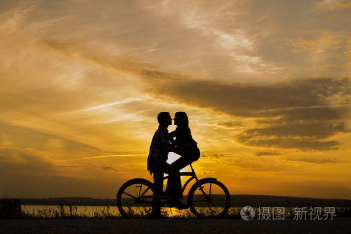 两个人约会时互相对视的剪影一对可爱的夫妇坐在一辆自行车上