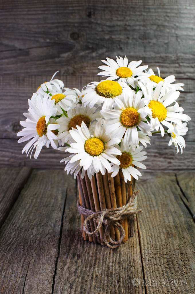 雏菊在竹花瓶的花束