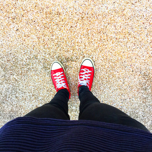 在地板上的女孩腿上的红色运动鞋的自拍照照片