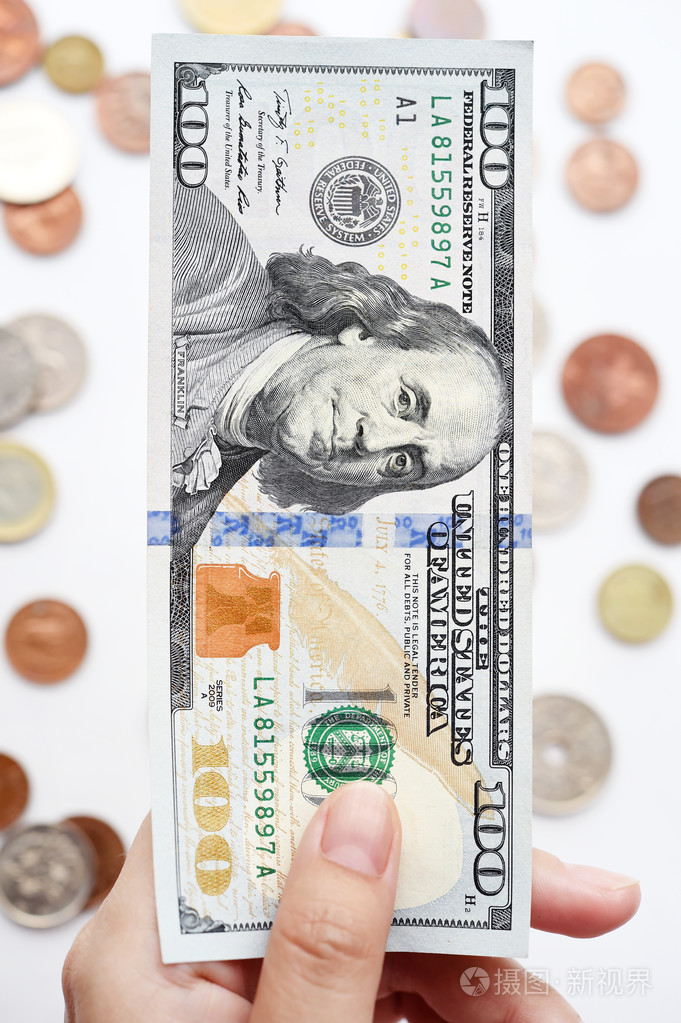 一百美元上的手和硬币