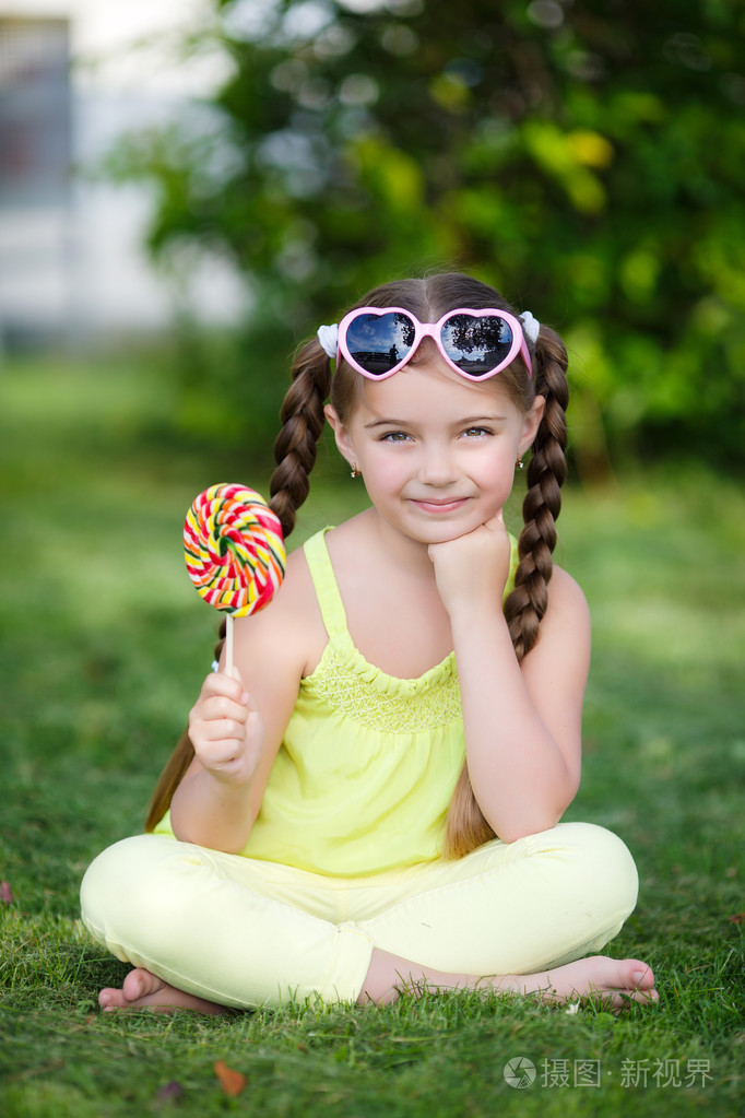 可爱的小女孩带着五颜六色的棒棒糖。