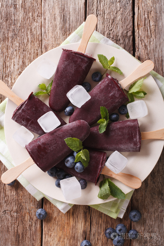 美味的蓝莓果汁冰糕在板上的棍子特写垂直