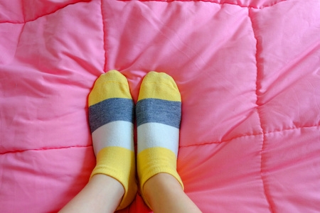 y女孩与粉红色条纹袜,睡在床上时尚漂亮的年轻女人穿着条纹膝盖袜子