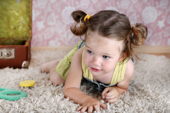 漂亮的小女孩在地毯上